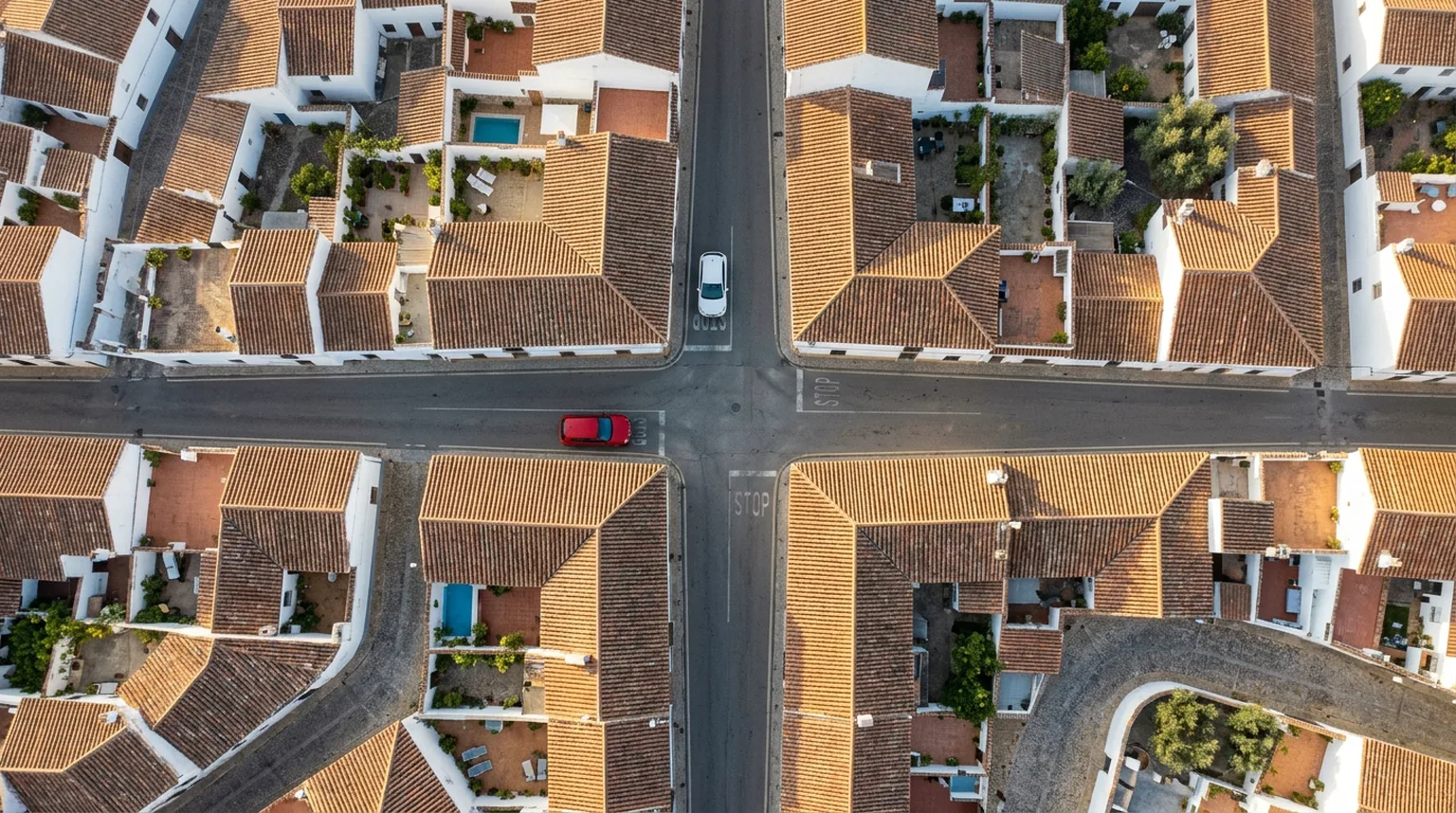 Cruce urbano visto desde arriba con dos coches aproximándose